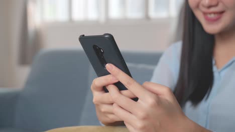 female using smartphone in living room, video in 4k