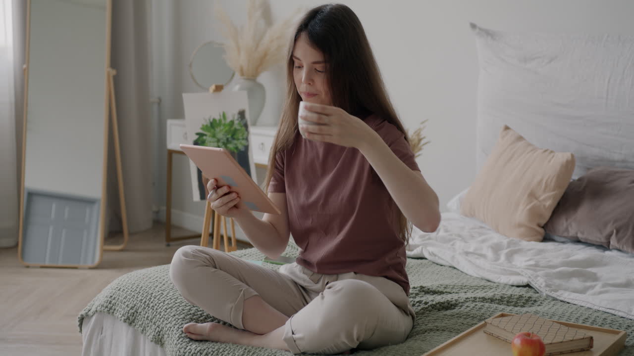 Woman Relaxing in Bedroom with Tablet and Coffee