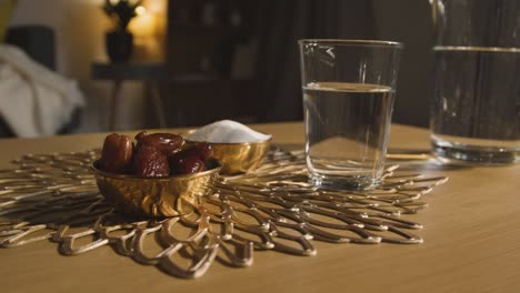 tazón de dátiles con un vaso de agua sobre la mesa en una casa musulmana celebrando el eid 4