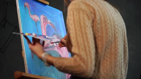 woman painting a flamingo