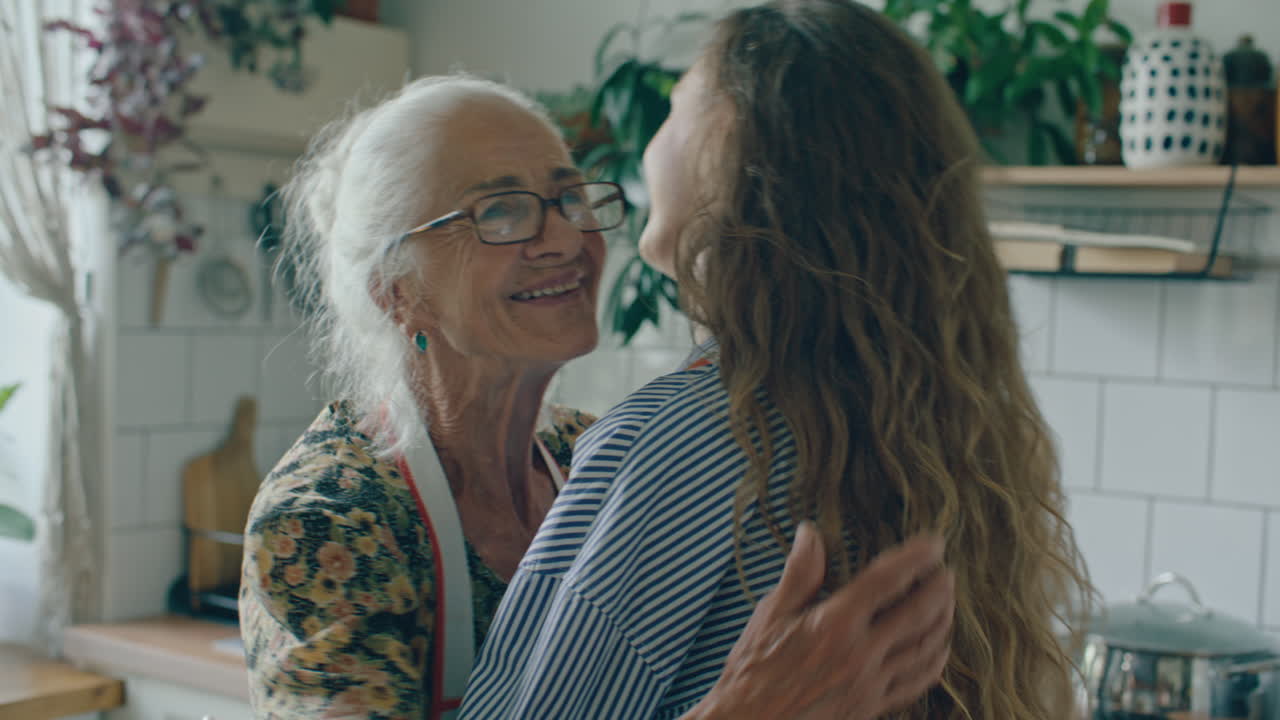 Joyful Elderly Woman Hugging Granddaughter in Kitchen