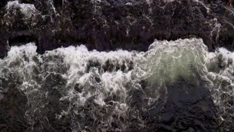 Das-Wasser-Im-Fluss-Fließt-Schnell-Und-Trifft-Auf-Eine-Sandbank-Unter-Wasser,-Wodurch-Wildwasser-An-Der-Oberfläche-Entsteht