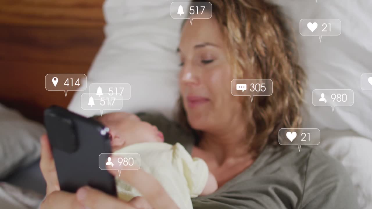 animación de iconos de redes sociales con números sobre mujer caucásica sosteniendo un bebé y usando un teléfono inteligente