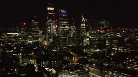 Slide-and-pan-footage-of-night-downtown-panorama.-Elevated-view-of-skyscrapers-in-City-financial-hub.-London,-UK