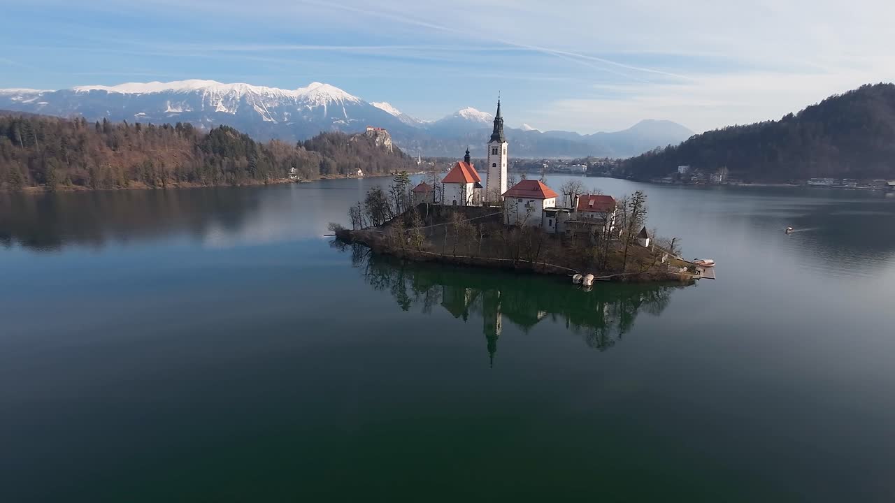 Veduta di profilo della Chiesa di Bled con le Alpi sullo sfondo.
