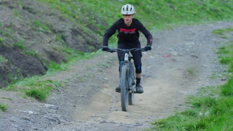 a mountain biker is blasting down a hill in slow motion