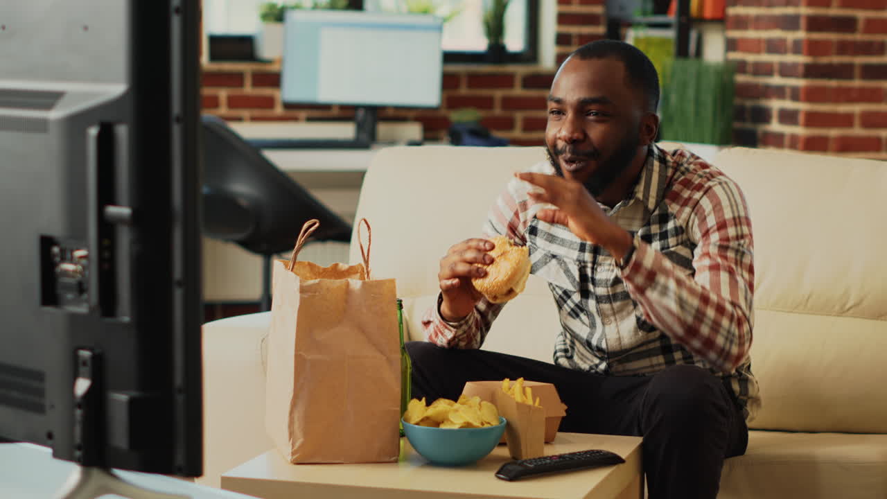 African american guy having fun eating burgers