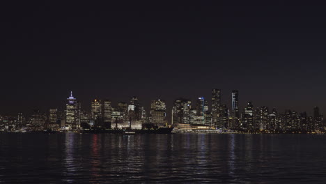 Speed-up-shot-of-cargo-ship-leaving-Vancouver-docks-at-night