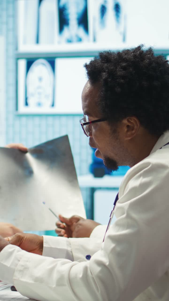 Vertical Video Radiologists and specialists examine x rays and discuss medical care