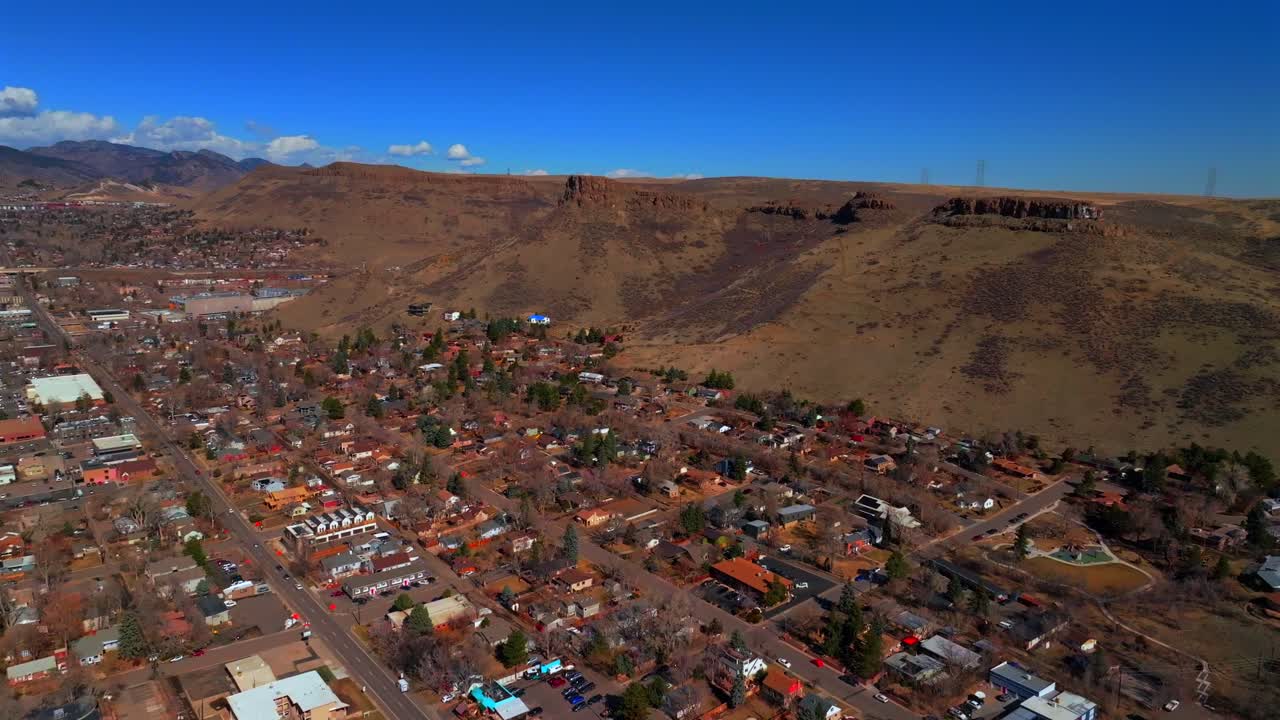 North Table Mountain Golden Colorado aerial drone Colorado historic downtown Golden Gate Canyon winter sunny morning afternoon blue sky Coors Beer Factory buildings homes neighborhoods forward motion