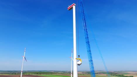 crawler crane next to wind turbine tower during assembly on wind farm