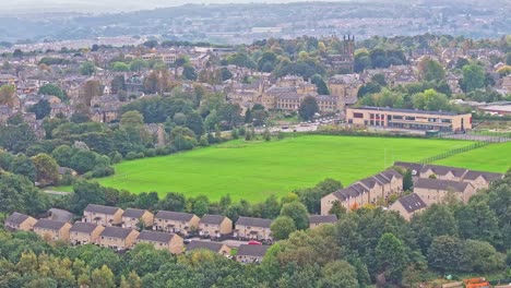 Drohne-Senkt-Sich-Unter-Eine-Wiese,-Umgeben-Von-Vorstadthäusern-In-Huddersfield,-England