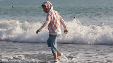 child playing in the waves at the beach