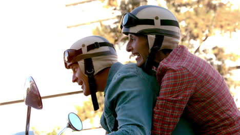 Pareja-De-Ancianos-Montando-Una-Scooter-Por-La-Ciudad