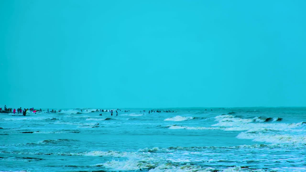 People enjoying the cool blue water of the Bay of Bengal, Indian Ocean