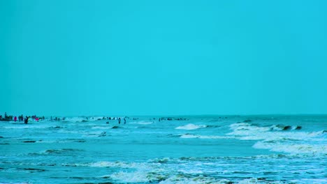 people enjoying the cool blue water of the bay of bengal, indian ocean