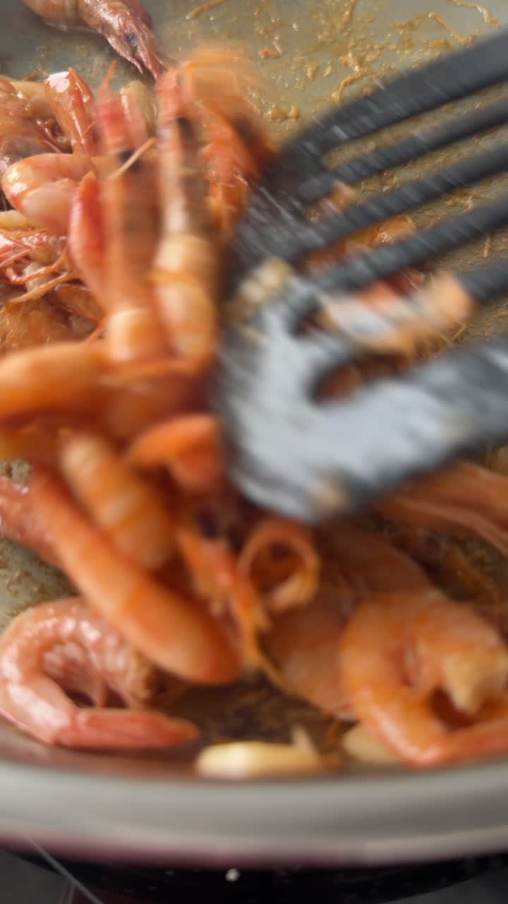 Cucinare gamberi con aglio in una padella