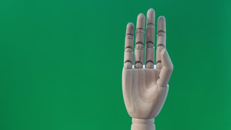 4k stop motion hand slowing love symbol on green backdrop, valentine’s day concept.