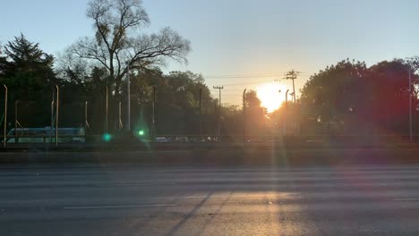 cars driving on a highway at sunset with lens flare