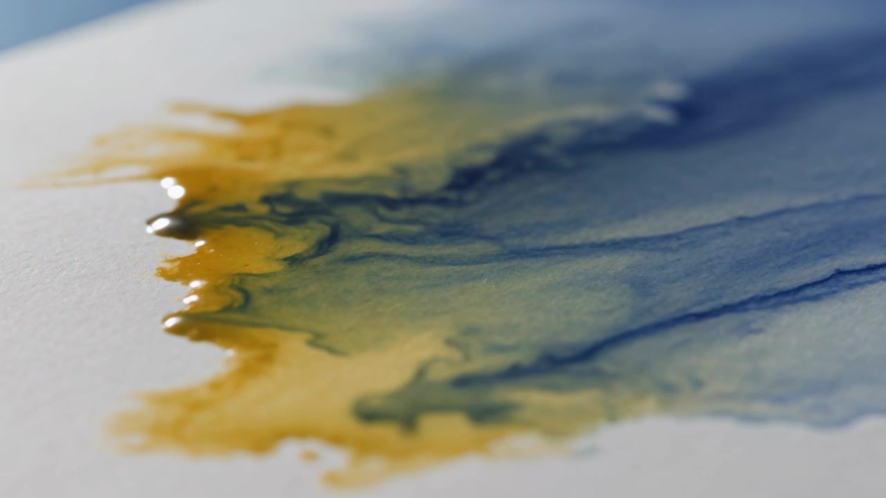 Ocra e blu freddo che si mescolano su carta acquerello in studio, con l'acqua accumulata che ne provoca la diffusione.