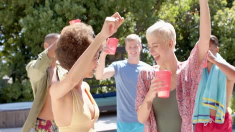 Feliz-Grupo-Diverso-De-Amigos-Haciendo-Barbacoa-Y-Bailando-En-Una-Fiesta-En-La-Piscina-En-Verano