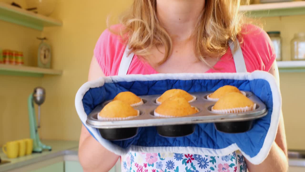 camarera sacando muffins del horno 4k