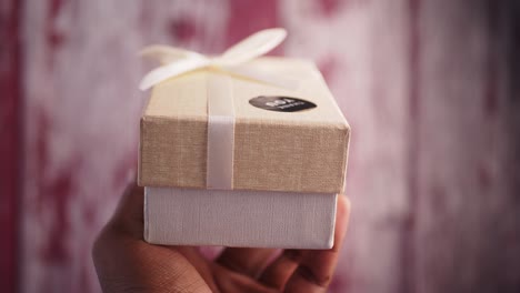 small beige gift box with white ribbon