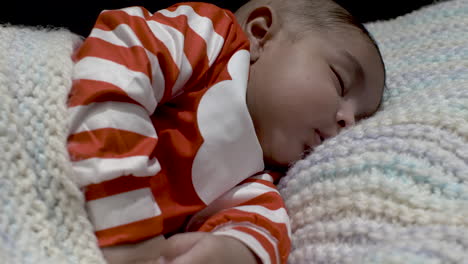 adorable 2 month old uk asian baby asleep on knitted blanket