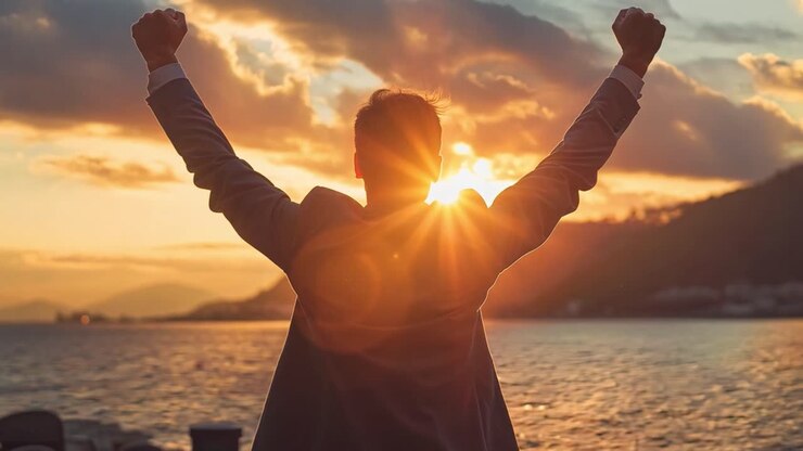 Uomo che celebra il successo al tramonto