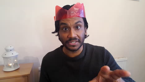 young man on christmas video call attempting to guess acted out word during charades game