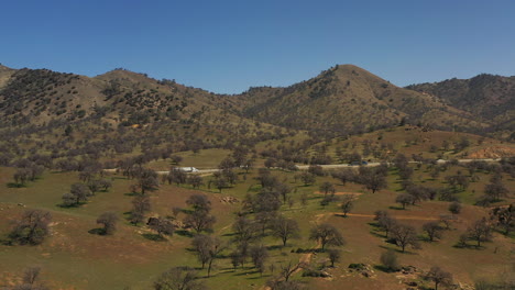 a highway runs through the picturesque tehachapi mountains in spring - aerial view