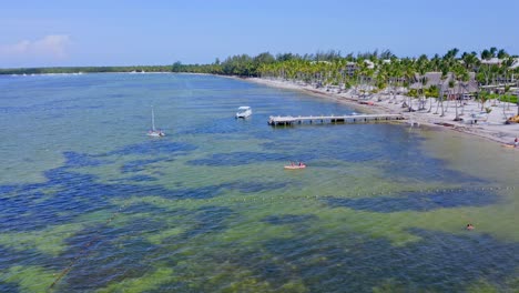 tourists enjoying kayak and sailboat adventure on the caribbean sea in bavaro beach, punta cana, dominican republic