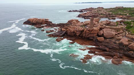 approaching panoramic drone movement the rocky côte de granit rose with the men ruz lighthouse and visitors, ploumanac'h, brittany, france