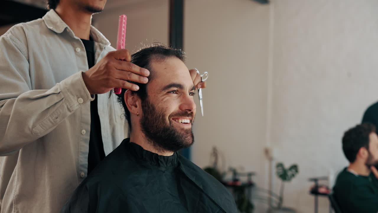 Glad mand får klippet hår af professionel frisør i en salon.