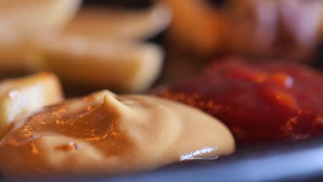 close up de patatas fritas sumergidas en mostaza y ketchup
