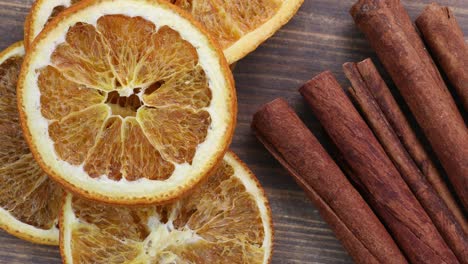 dried oranges with cinnamon on a wooden background