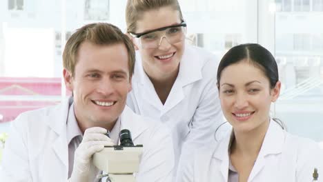 three chemists with a microscope