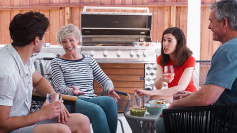 senior couple and adult children talking in their backyard