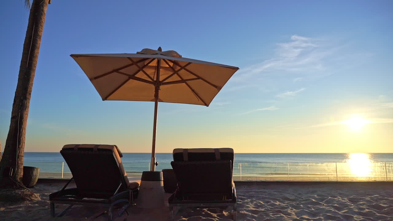 Scenic holiday beach with deckchairs and sun umbrella, daylight static