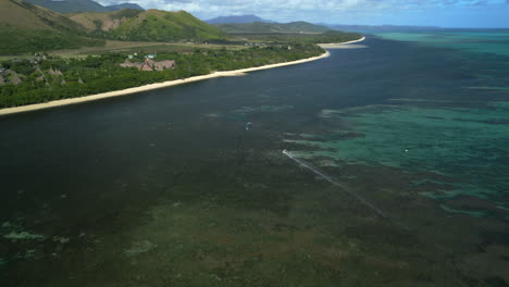 kiteboarding en aguas poco profundas de la playa de poe cerca de domaine de deva, nueva caledonia - aérea