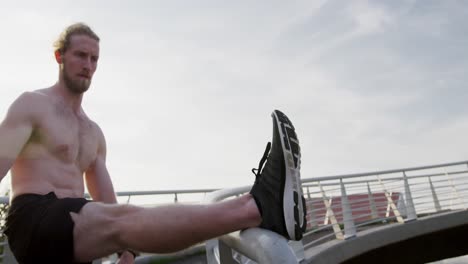 Sporty-Caucasian-man-training-on-a-bridge