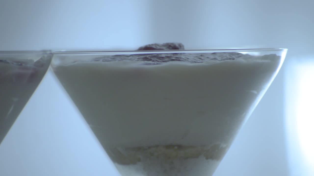 tarta de queso cremosa en el vaso con galletas desmenuzadas en el fondo y fruta en gelatina encima, panorámica