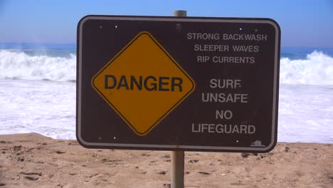 Un-Letrero-A-Lo-Largo-De-Una-Playa-De-California-Advierte-Sobre-Olas-Peligrosas-Y-Fuertes-Corrientes-De-Resaca-1