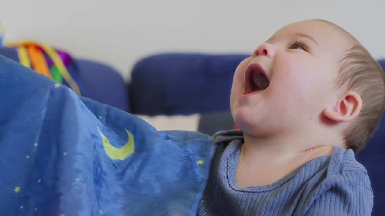 bebê brincando com fitas de seda arco-íris em câmera lenta