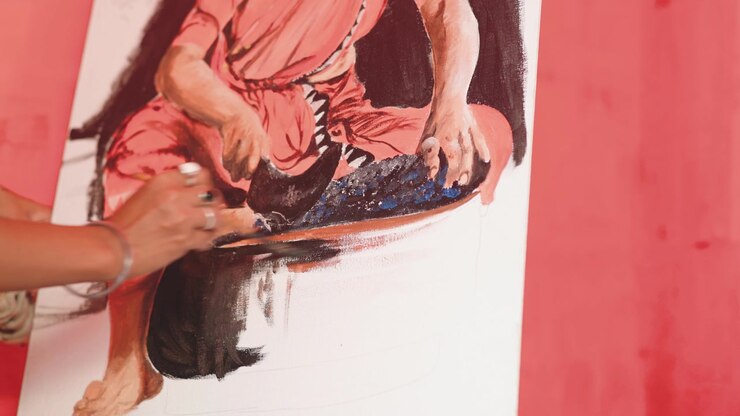 Weibliche Hand mit Fingerringen malt ein beeindruckendes Kunstwerk im Atelier, ruhige Nahaufnahme.