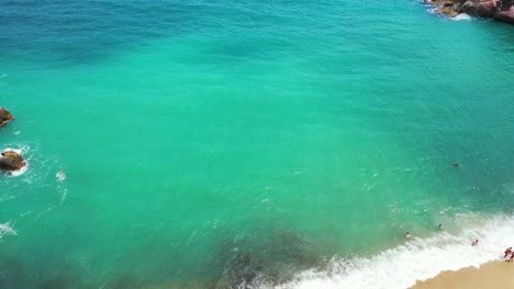 tourists swiiming in the wavy aquamarine sea