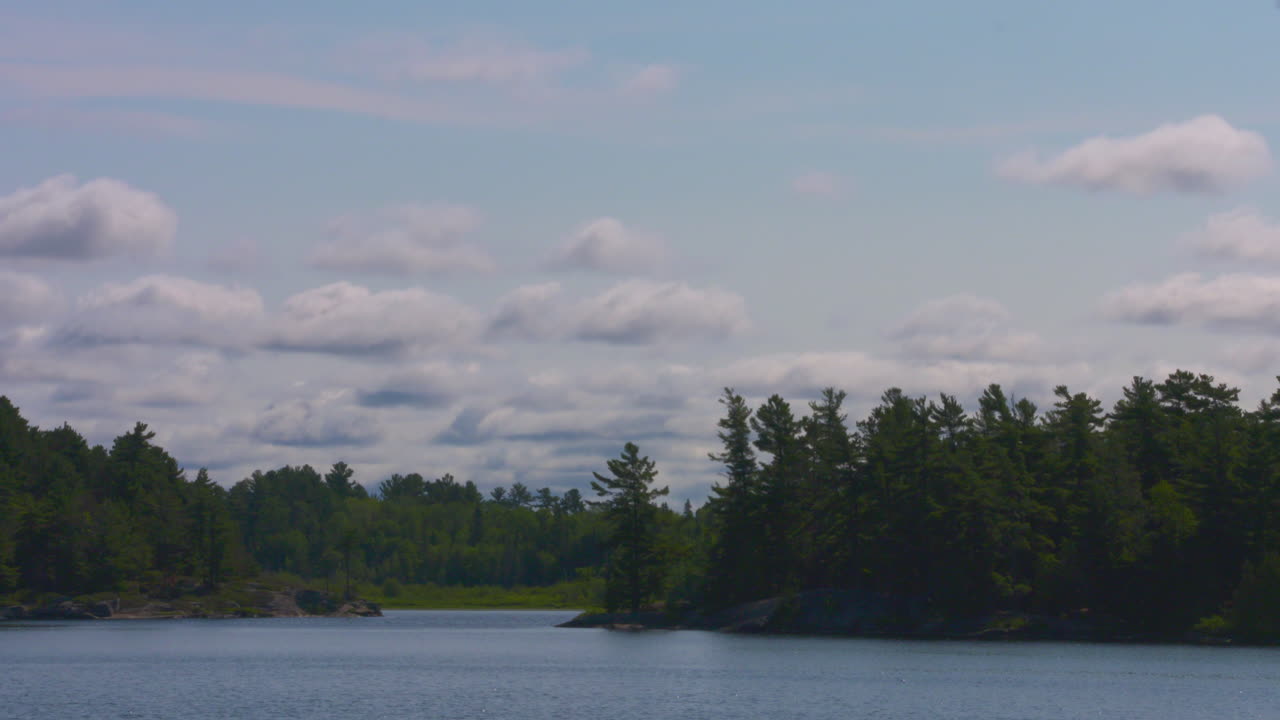 lapso de tiempo de nubes blancas y esponjosas que pasan sobre un hermoso entorno de verano frente al lago