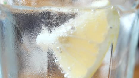 close-up of a lemon slice in a glass of water with ice