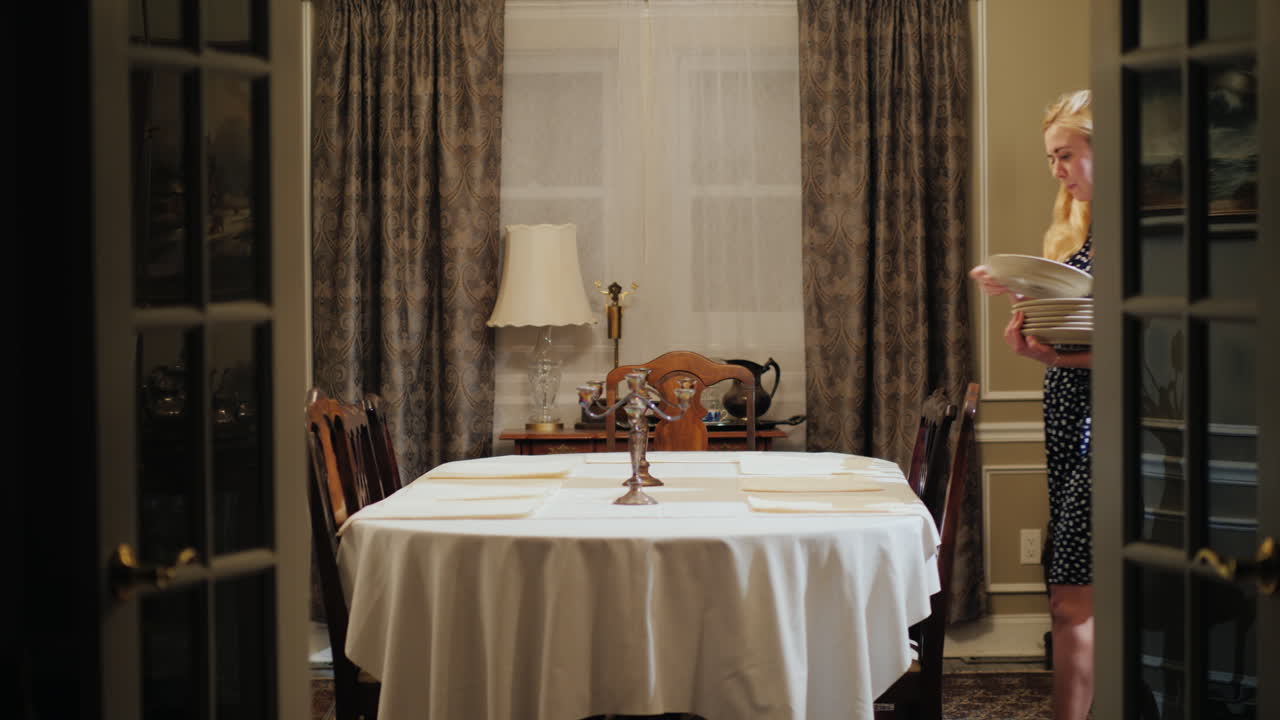 una mujer sirve una mesa en un comedor de casa