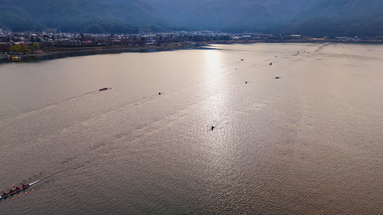 Aerial drone view of rowing boats moving on Lake Kawaguchiko near the Fujikawaguchiko town, Japan